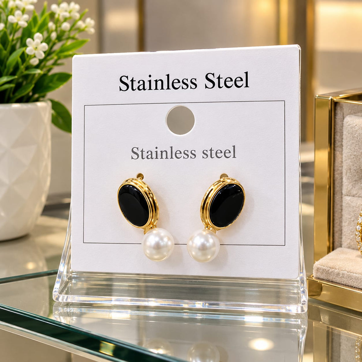 Elegant Black & Pearl Drop Earrings – Stainless Steel Add a touch of elegance to your style with these beautiful black oval and pearl drop earrings. Featuring a glossy black design, a luxurious gold-tone frame, and elegant pearl details,
